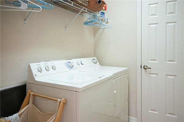 clothes washing area featuring laundry area and washer and clothes dryer