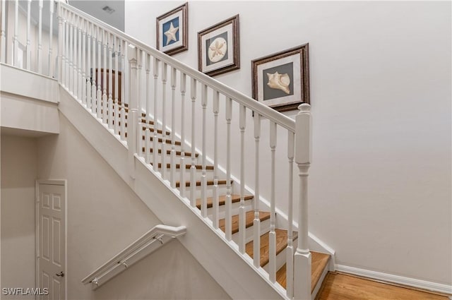 stairs featuring visible vents, baseboards, and wood finished floors