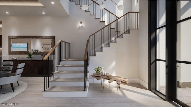 stairs featuring a high ceiling, recessed lighting, wood finished floors, and baseboards