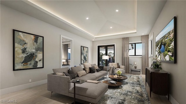 living area featuring recessed lighting, baseboards, a tray ceiling, and wood finished floors