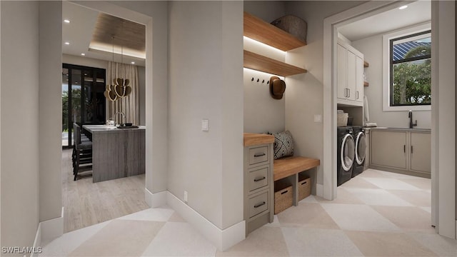 mudroom with light floors, baseboards, washing machine and clothes dryer, recessed lighting, and a sink