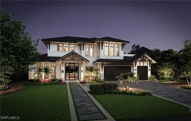 view of front of property with a front lawn, decorative driveway, and a garage