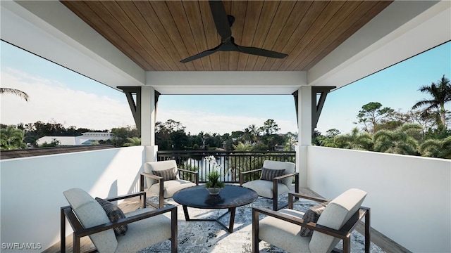 view of patio featuring a balcony, a water view, and ceiling fan