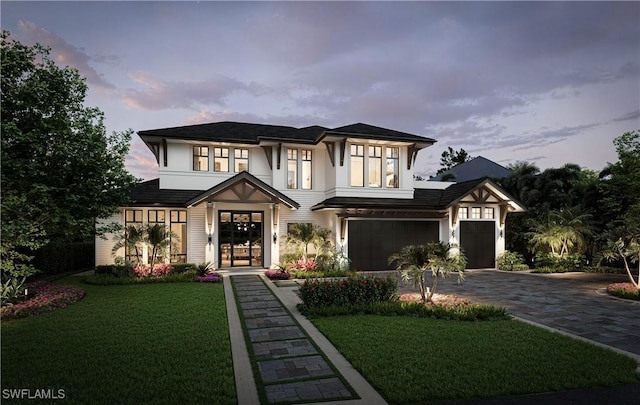 view of front of property with an attached garage, decorative driveway, and a front yard