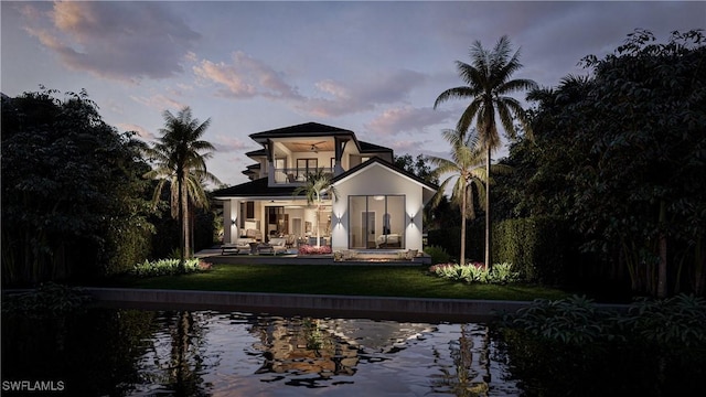 rear view of house with a yard, a patio area, a balcony, and stucco siding