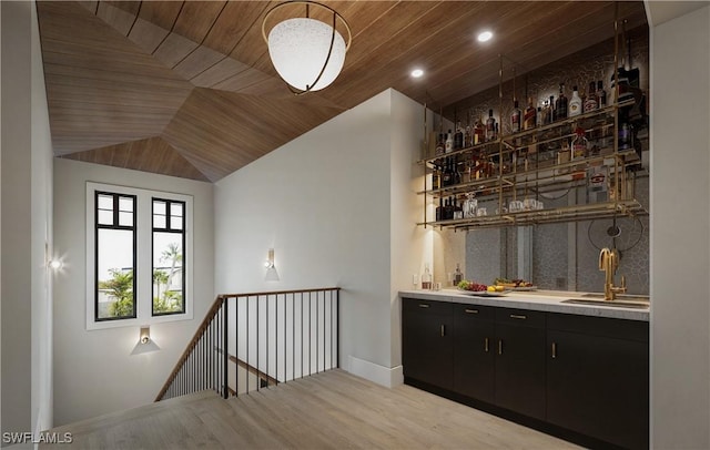 bar with indoor wet bar, wooden ceiling, wood finished floors, and a sink