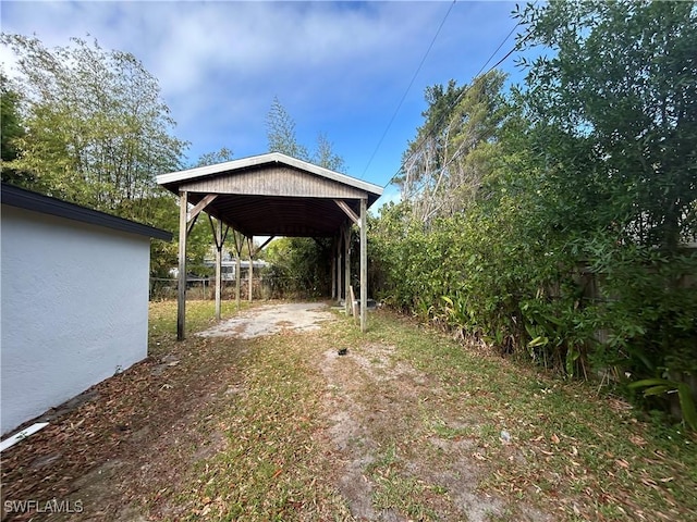 view of yard featuring fence and a detached carport