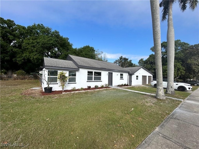 view of front facade featuring an attached garage, driveway, a shingled roof, and a front yard