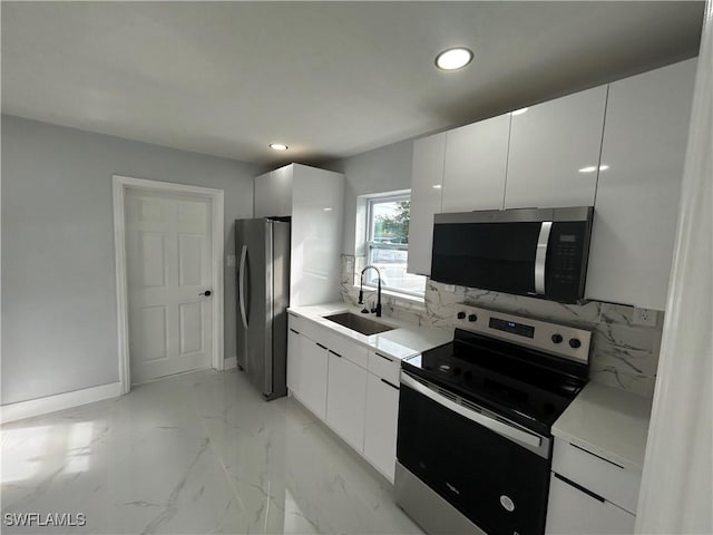 kitchen featuring appliances with stainless steel finishes, white cabinets, a sink, and modern cabinets