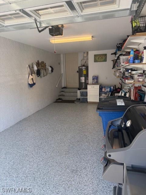 garage with water heater and a garage door opener