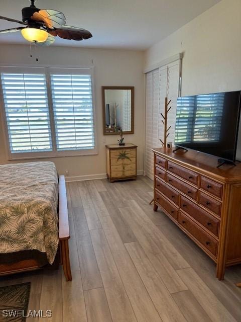 bedroom with wood finished floors, a ceiling fan, and baseboards