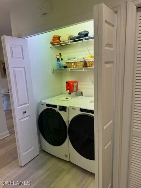 washroom featuring laundry area, light wood finished floors, and washer and clothes dryer