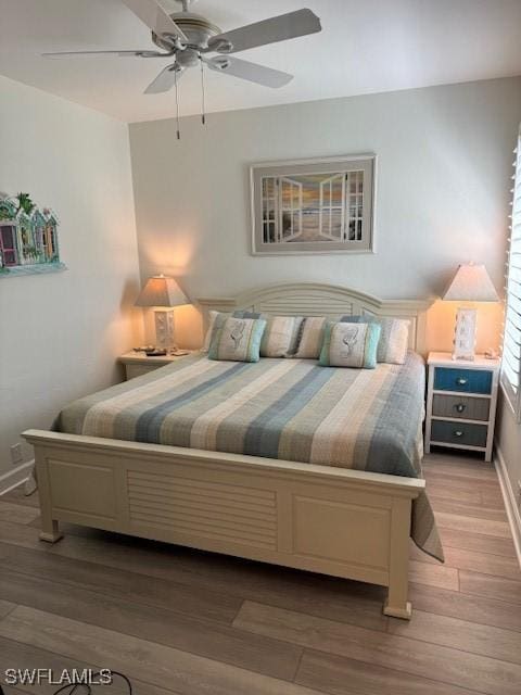 bedroom with ceiling fan, baseboards, and wood finished floors