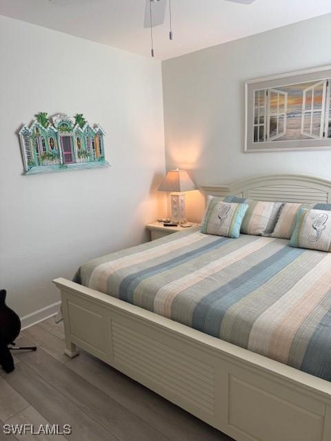 bedroom featuring baseboards and wood finished floors