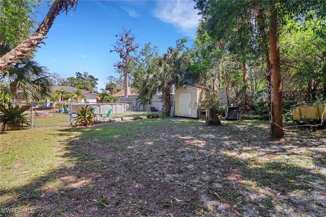 view of yard featuring an outbuilding, fence, and a storage shed