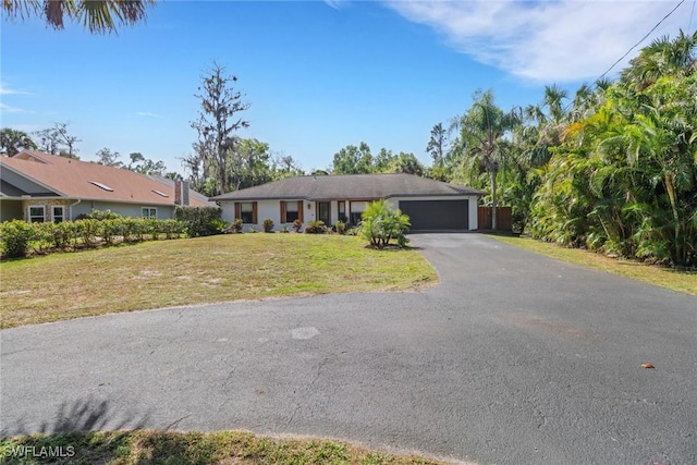 ranch-style home featuring a garage, aphalt driveway, and a front lawn