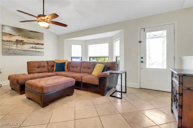 living room featuring a wealth of natural light, vaulted ceiling, baseboards, and ceiling fan