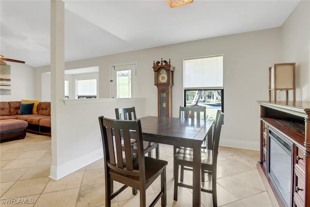 dining room with light tile patterned floors, baseboards, and a glass covered fireplace