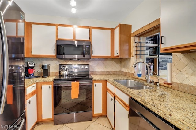 kitchen featuring dishwasher, stainless steel microwave, freestanding refrigerator, black electric range, and a sink