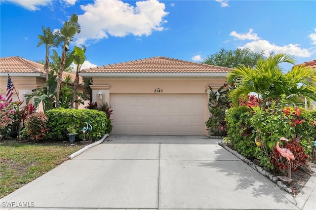 mediterranean / spanish-style house featuring a garage, a tiled roof, and stucco siding