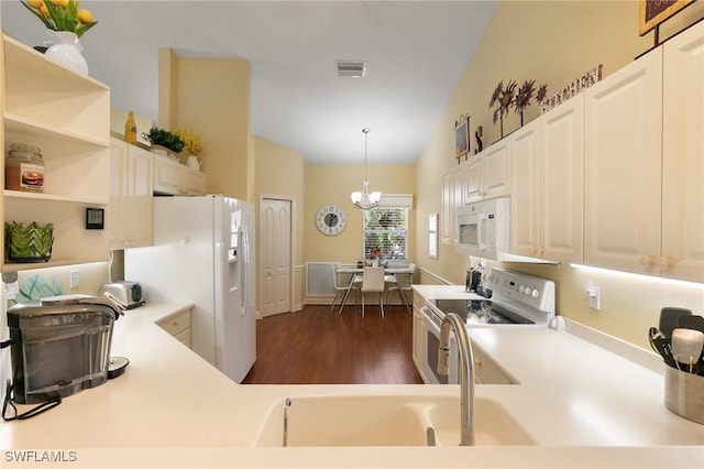 kitchen featuring white appliances, visible vents, decorative light fixtures, light countertops, and a notable chandelier