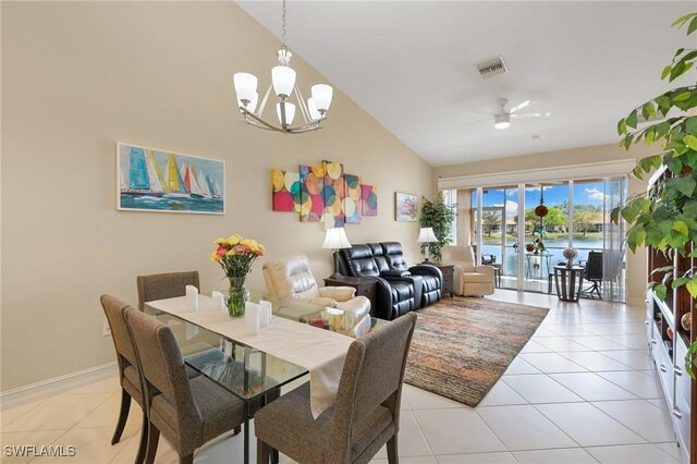 dining space featuring a water view, visible vents, lofted ceiling, ceiling fan with notable chandelier, and light tile patterned floors