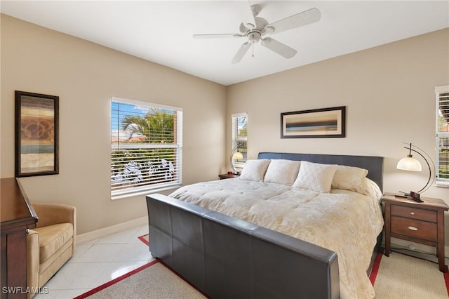 bedroom featuring light tile patterned floors, baseboards, and a ceiling fan