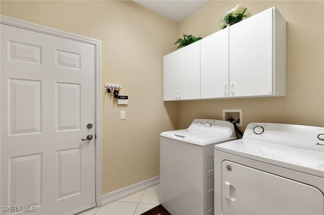 laundry room with washer and dryer, baseboards, cabinet space, and light tile patterned flooring