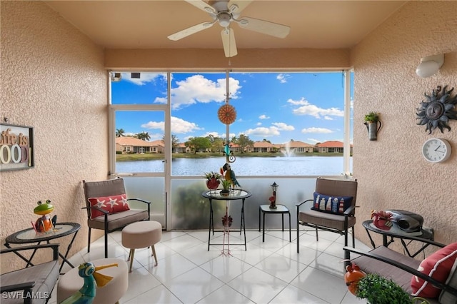 sunroom with a textured wall, tile patterned flooring, and a water view