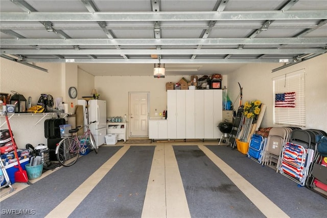 garage with freestanding refrigerator and a garage door opener