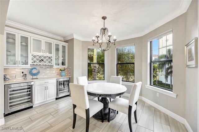 dining area with beverage cooler, ornamental molding, a dry bar, and baseboards