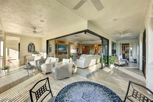 living room with arched walkways and a ceiling fan