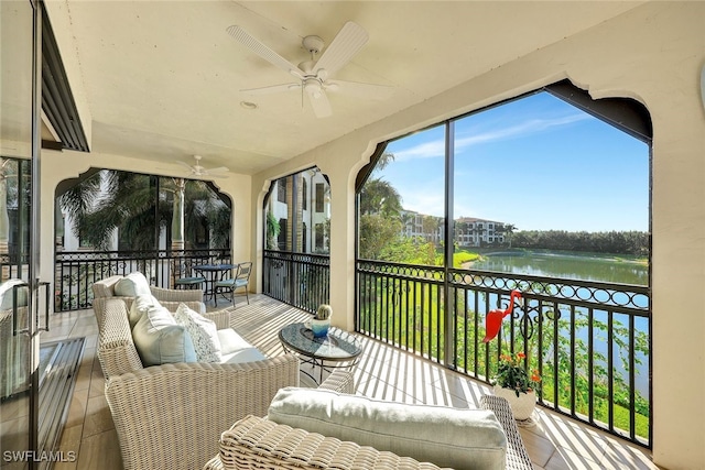 sunroom featuring outdoor lounge area, ceiling fan, and a water view