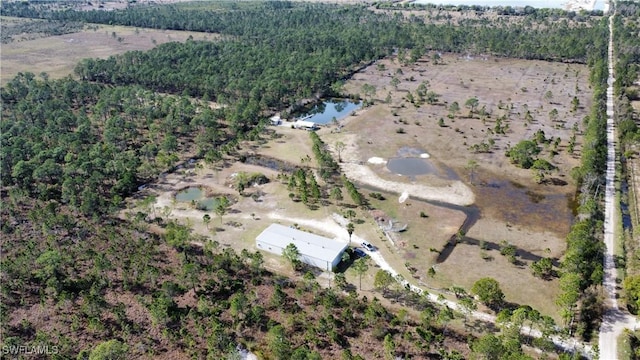 bird's eye view with a water view and a wooded view