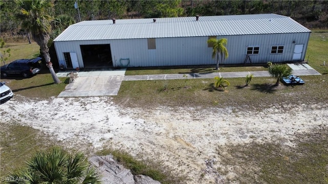 exterior space with a garage, an outbuilding, a pole building, and metal roof