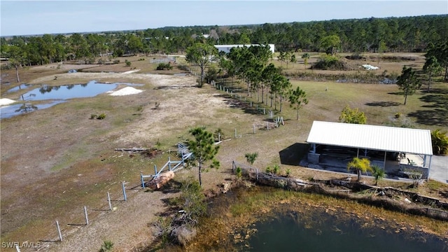 drone / aerial view featuring a forest view and a water view