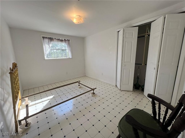 bedroom with light floors, a closet, and baseboards