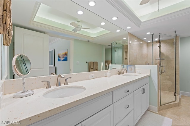 bathroom featuring ceiling fan, a tray ceiling, and a sink