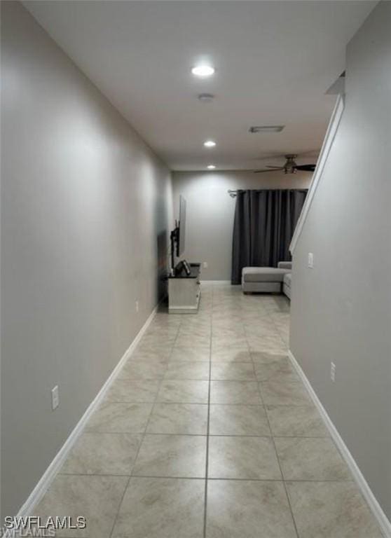 hall with light tile patterned floors, recessed lighting, and baseboards