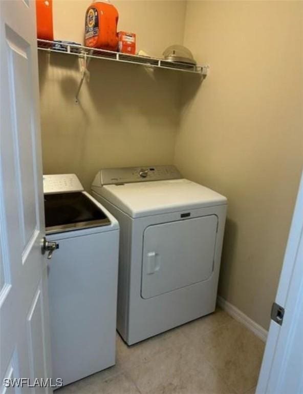 washroom with baseboards, laundry area, and washer and dryer