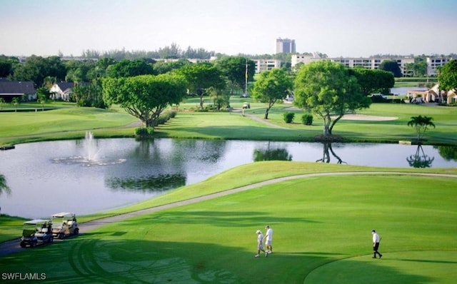 view of property's community featuring golf course view, a water view, and a lawn