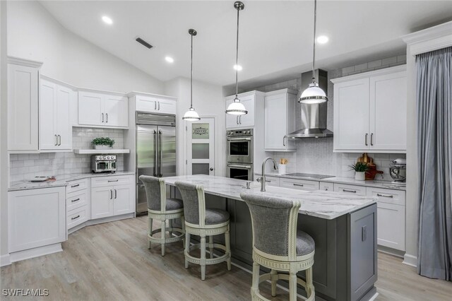 3311 Creekview Dr, Bonita Springs, FL 34134 - kitchen featuring stainless steel appliances, decorative backsplash, white cabinets, a center island with sink, and vaulted ceiling