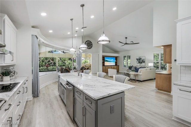 3311 Creekview Dr, Bonita Springs, FL 34134 - kitchen with gray cabinetry, high vaulted ceiling, light wood-type flooring, an island with sink, and light stone counters