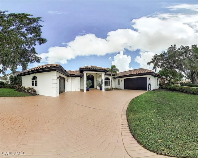 3311 Creekview Dr, Bonita Springs, FL 34134 - mediterranean / spanish-style house featuring a garage, decorative driveway, a front lawn, and stucco siding