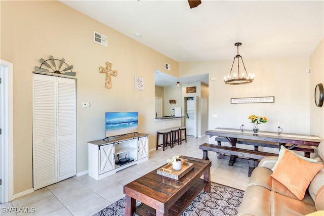 living room featuring light tile patterned floors, visible vents, and a notable chandelier