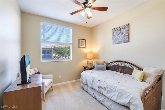 bedroom with light colored carpet, a ceiling fan, and baseboards