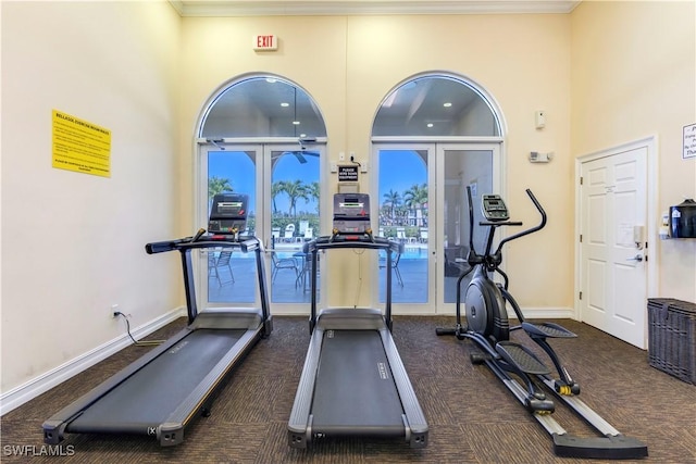 workout area featuring french doors, baseboards, and a towering ceiling