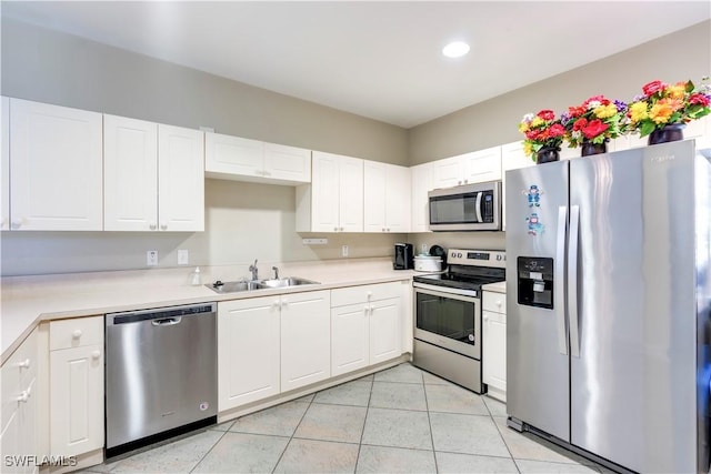 kitchen featuring light countertops, white cabinets, appliances with stainless steel finishes, and a sink