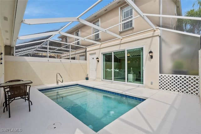 view of pool with glass enclosure, a fenced in pool, and a patio area