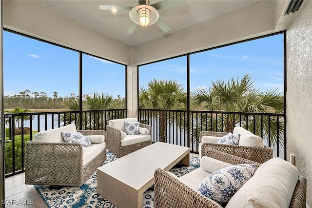 sunroom featuring a water view and ceiling fan